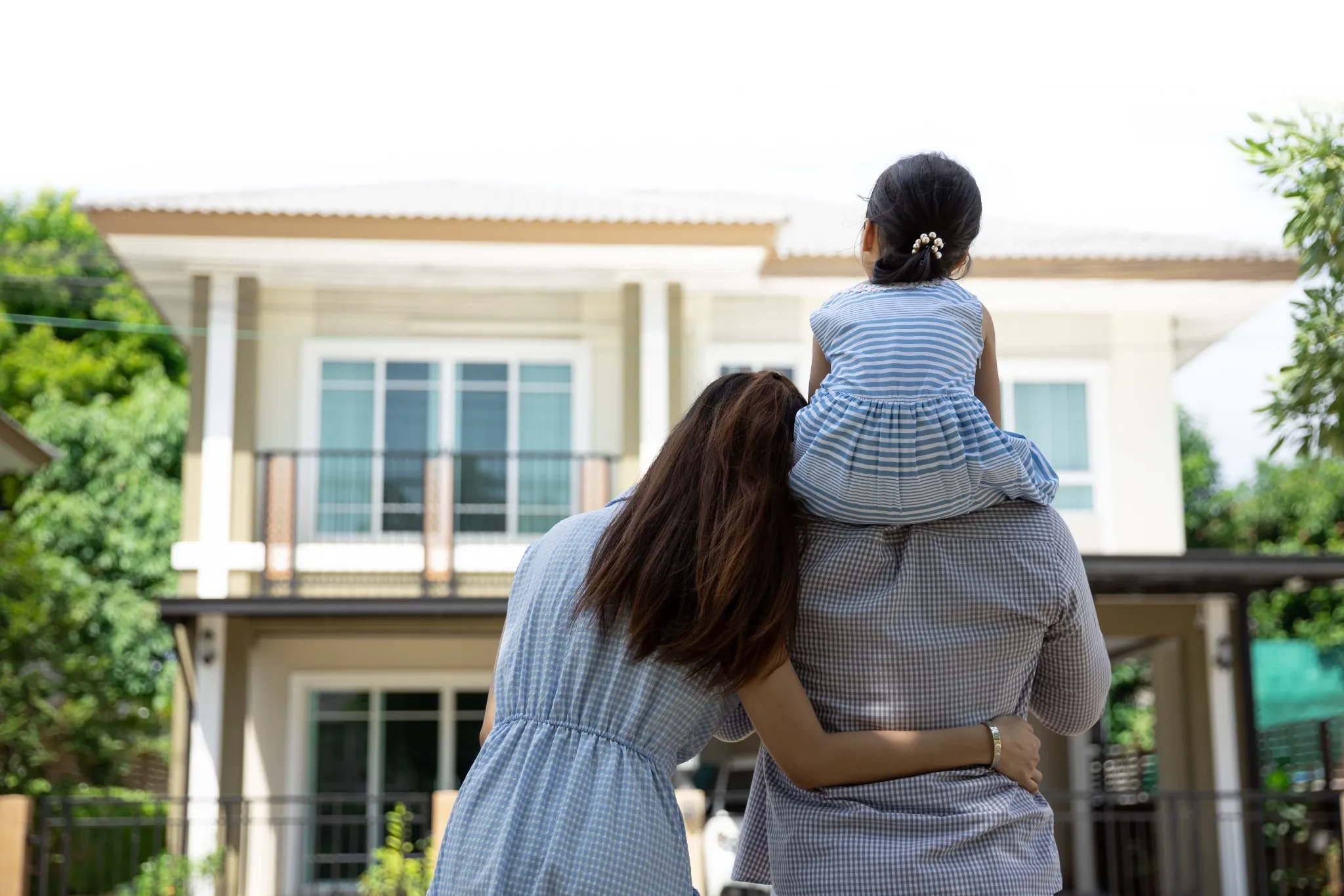 Family of three looking at their house