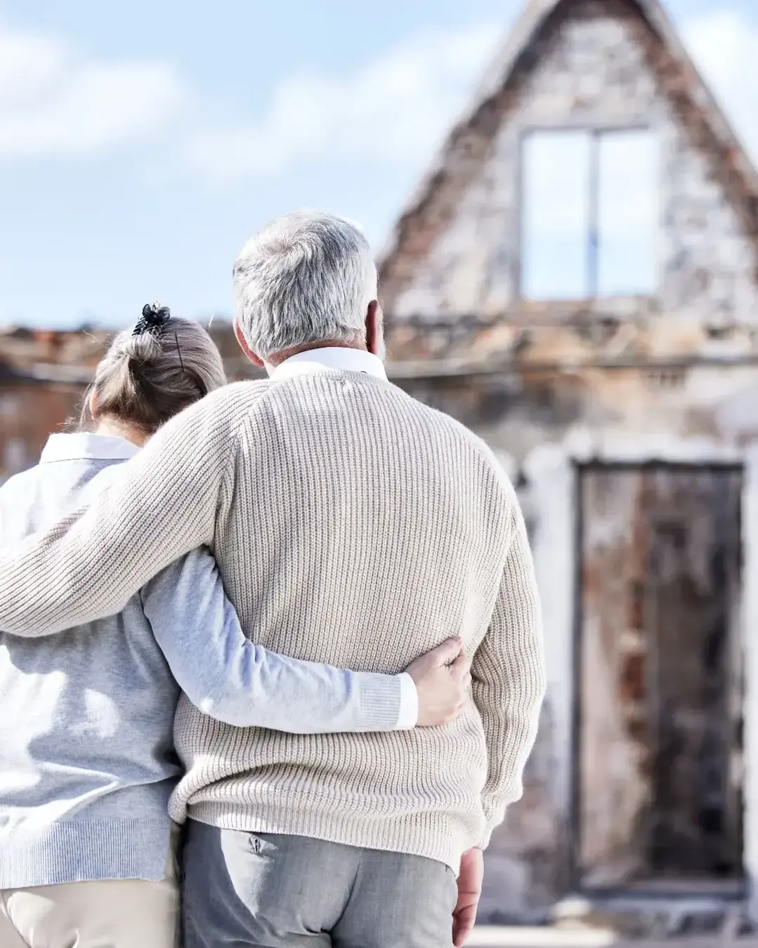 People looking at their burnt down house