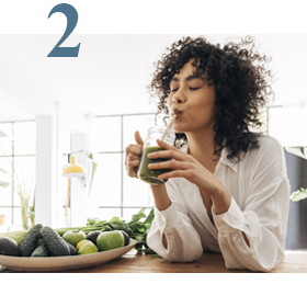 woman drinking green smoothie in apartment